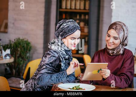 Zwei muslimischen Frauen im Cafe, Shop online über elektronische Tablet Stockfoto