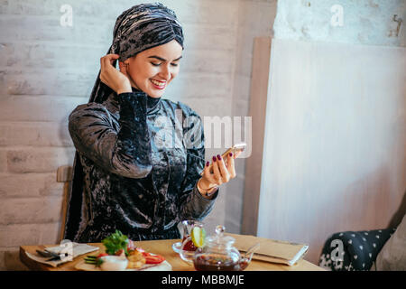 Muslimische Frauen Holding smartphonephone. Denken gute Erinnerungen. Stockfoto