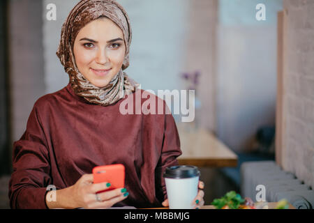 Muslimische Frauen Holding smartphonephone. Denken gute Erinnerungen. Stockfoto