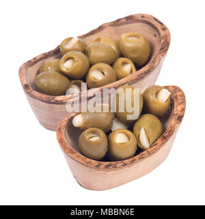 Grüne kolossale Oliven gefüllt mit Knoblauch Handschuhe Hand in Olivenholz Schüssel Stockfoto