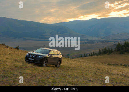 Crossover Nissan X-Trail auf einem Hang in Kurai Steppe vor dem Hintergrund des Nordens Chuy ridge in der Morgendämmerung. Stockfoto