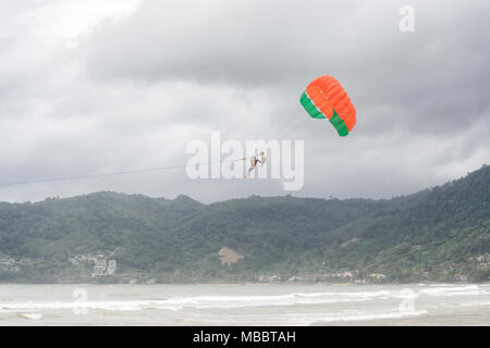 PHUKET, Thailand - August 01, 2013: Parasailing ohne Lizenz und Ausrüstung, nur durch barehanded Mann gesteuert. Stockfoto