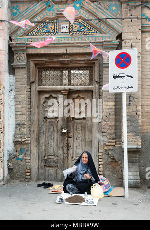 Mashhad, Iran - 30. Juli 2016: iranische Frau sitzt auf dem Bürgersteig Gewürze verkaufen in Street Market Stockfoto