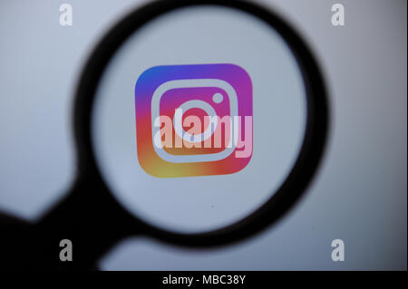 Die Instagram Logo durch eine magnifiying Glas gesehen Stockfoto