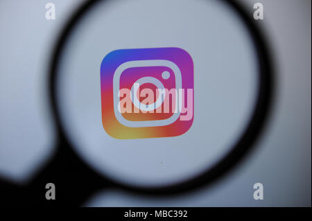 Die Instagram Logo durch eine magnifiying Glas gesehen Stockfoto