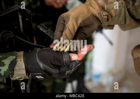 Ein Soldat der US-Armee von Delta Unternehmen, 1.Bataillon, 21 Infanterie Regiment, 2 Infantry Brigade Combat Team, 25 Infanterie Division, sortiert leer 5,56 mm rundet mit seinem Royal Thai Army Gegenstück vom 2nd Battalion, 3. Marine Regiment bei einer militärischen Operationen in urbanem Gelände (mout) Schulungsveranstaltung während der Übung Cobra Gold 2018 auf Lager Freundschaft in Korat, Königreich Thailand, 13.02.2018. Cobra Gold, in seiner 37. Iteration, ist entworfen, um die regionale Sicherheit zu fördern und wirksame Antworten auf regionale Krisen sicherzustellen, indem eine robuste multinationale Truppe geteilt zu Adresse Stockfoto