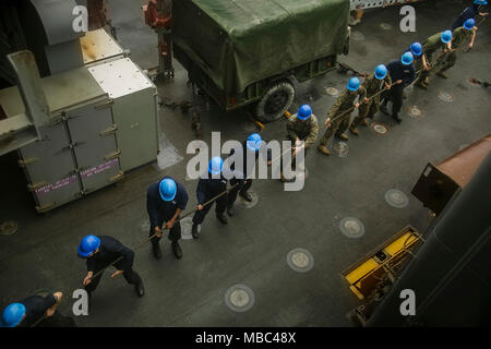 Us-Marines mit dem 26 Marine Expeditionary Unit (MEU) und die US-amerikanische Segler belegt das Dock Landung Schiff USS Oak Hill (LSD 51) arbeiten zusammen, während eine Auffüll-anforderung auf See an Bord der Oak Hill während der Fahrt in den Atlantik, 13.02.2018. Die 26. MEU ist die Teilnahme an einem Einsatz auf See see- und friedenserhaltende Maßnahmen durchzuführen, sowie die Pflege der Beziehungen zu ausländischen Armeen durch gemeinsame Übungen. (U.S. Marine Corps Stockfoto