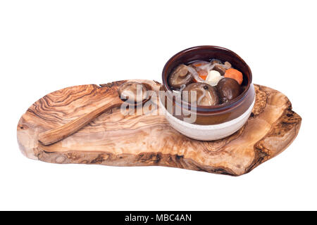 Shiitake Pilze mariniert in Keramik Schüssel mit Löffel aus Holz auf olivenholz Schneidbrett auf weißem Hintergrund Stockfoto