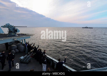 Schwarzes Meer (13. Februar 2018) Matrosen an Bord Standing NATO Maritime Group 2 (Snmg 2) Flaggschiff, Royal Navy Typ 45 Zerstörer HMS Duncan, Wave als bulgarische Fregatte BGS Smeli Segel Vergangenheit während eines vorbeifahrenden Übung mit der Bulgarischen Marine. Die NATO Stockfoto