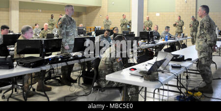 Master Sgt. Kevin Burr, 66th Truppe Befehl (stehend, links) erklärt seine Rolle in der Joint Operations Center zu Generalmajor Janson D. Boyles, der Adjutant General von Mississippi, während der Patriot South 2018 im Camp Shelby Joint Forces Training Center 14.02.2018. Übung Patriot South ist ein drei-Feld Tag der Übung, die die Tests der National Guard Fähigkeit Reaktion bei Naturkatastrophen zu unterstützen. (U.S. Army National Guard Stockfoto