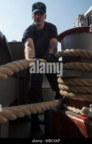 LAEM CHABANG, Thailand (Feb. 14, 2018) Richard Seaman Crowden, aus Middleville, Mich., wuchtet eine Verankerung im Meer-und-anker detail an Bord der Amphibisches Schiff USS BONHOMME RICHARD (LHD6) als das Schiff fährt Laem Chabang, Thailand, Übung Cobra Gold 2018 zu unterstützen. Bonhomme Richard beteiligt sich an CG 18 neben Royal Thai Navy Schiffe und Personal, die Durchführung einer Reihe von Amphibischen Operationen, die taktischen Kompetenzen der Teilnehmer und Flex kombiniert Funktionen für unvorhergesehene Ereignisse zu reagieren, verbessert wird. Cobra Gold ist eine jährliche Übung im Königreich Thailand durchgeführt. Stockfoto