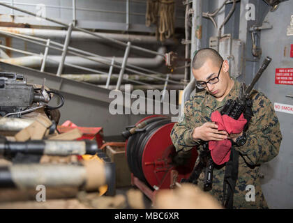 Ozean (Feb. 14, 2018) Lance Cpl. Matthäus Cortes aus Long Island, New York, reinigt ein M4 Gewehr an Bord der Station Landung Schiff USS Oak Hill (LSD 51). Die Iwo Jima Amphibious Ready Gruppe begibt sich die 26 Marine Expeditionary Unit und umfasst Oak Hill, die Amphibisches Schiff USS Iwo Jima (LHD7), die amphibious Transport dock Schiff USS New York (LPD 21), Flotte Op-Team 8, Hubschrauber Meer Combat Squadron 28, Tactical Air Control Squadron 22, Komponenten der Naval Beach Gruppe 2 und die begonnen, Mitarbeiter der Amphibischen Squadron 4. (U.S. Marine Stockfoto