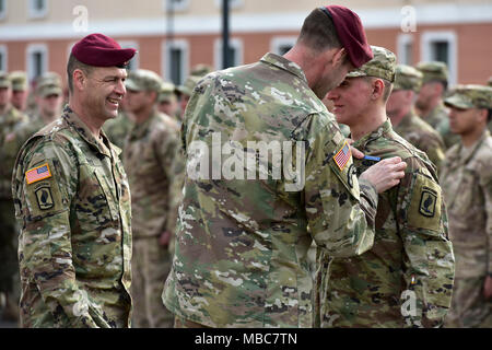 Oberst James B. Bartholomees III, Kommandant der 173Rd Airborne Brigade (rechts) und den Befehl Sgt. Maj. Franklin Velez Der 173Rd Airborne Brigade (links), die Stifte der Experte Infanterist Abzeichen (EIB) auf ein Fallschirmjäger auf die 173Rd Airborne Brigade während der Experte Infanterist Abzeichen (EIB) Zeremonie an Caserma Del Din, Vicenza, Italien, 15. Febr. 2018 zugeordnet. (U.S. Armee Stockfoto