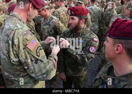 Oberst James B. Bartholomees III, Kommandant der 173Rd Airborne Brigade (Links), stellt die 173Rd Airborne Brigade Schulter sleeve Insignia auf einem Polen Armee Soldat während der Experte Infanterist Abzeichen (EIB) Zeremonie an Caserma Del Din, Vicenza, Italien, 15. Febr. 2018. (U.S. Armee Stockfoto