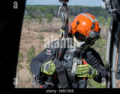 Emerson Kovalanchik, S.C. Hubschrauber Aquatic Rescue Team, verlässt eine UH-60 Black Hawk während der Gemeinsamen helicopter Rescue hoist Training mit Alpha Company, 1-111 th Aviation Battalion, S.C. Nationalgarde während der PATRIOT South 2018, Camp Shelby, Hattiesburg, Fräulein, Feb 15, 2018. PATRIOT ist ein inländischer Operations Training übung durch die Nationalgarde gefördert, die auf das Verständnis der Koordinierung, Richtlinien und Verfahren bei der Durchführung einer gemeinsamen Inter-Agency inländischen Reaktion erforderlich ist. (U.S. Air National Guard Stockfoto