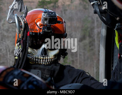 Emerson Kovalanchik, S.C. Hubschrauber Aquatic Rescue Team, verlässt eine UH-60 Black Hawk während der Gemeinsamen helicopter Rescue hoist Training mit Alpha Company, 1-111 th Aviation Battalion, S.C. Nationalgarde während der PATRIOT South 2018, Camp Shelby, Hattiesburg, Fräulein, Feb 15, 2018. PATRIOT ist ein inländischer Operations Training übung durch die Nationalgarde gefördert, die auf das Verständnis der Koordinierung, Richtlinien und Verfahren bei der Durchführung einer gemeinsamen Inter-Agency inländischen Reaktion erforderlich ist. (U.S. Air National Guard Stockfoto