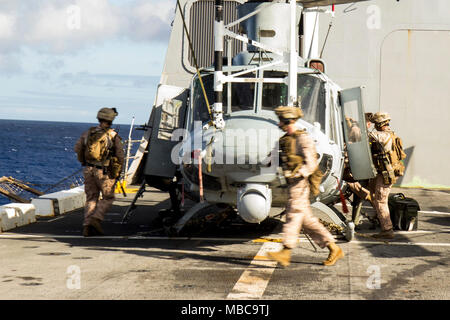 Us-Marines und Matrosen mit Bataillon Landung Team 2 Bataillon, 6 Marine Regiment, 26 Marine Expeditionary Unit (MEU) laden ein simulierter Unfall während des Ein- und Ausschalten Bohrer, das Üben der Grundlagen der erste an Bord einer UH-1Y Venom Hubschrauber Auf- und Absteigen auf eine simulierte Landung an Bord des amphibious Transport dock USS New York (LPD 21) Feb 14, 2018. Die 26. MEU ist die Teilnahme an einem Einsatz auf See see- und friedenserhaltenden Maßnahmen durchzuführen, sowie die Pflege der Beziehungen zu ausländischen Armeen durch gemeinsame Übungen. (U.S. Marine Corps Stockfoto