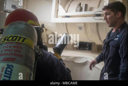 Ozean (Feb. 17, 2018) Rumpf Techniker 1. Klasse James McCaston, von Lexington, South Carolina, Züge Machinist Mate 3. Klasse Christopher Smudzinski, von Hot Springs, Florida, wie Hotspots während der Brandbekämpfung Bohrer zu bekämpfen an Bord des amphibious Transport dock Schiff USS New York (LPD-21). Die Iwo Jima Amphibious Ready Gruppe begibt sich die 26 Marine Expeditionary Unit und umfasst die Amphibious Assault ship USS Iwo Jima (LHD7), New York, das Dock Landung Schiff USS Oak Hill (LSD 51), Flotte Op-Team 8, Hubschrauber Meer Combat Squadron 28, Tactical Air Control Squadron 22, Bauteile mit Nava Stockfoto