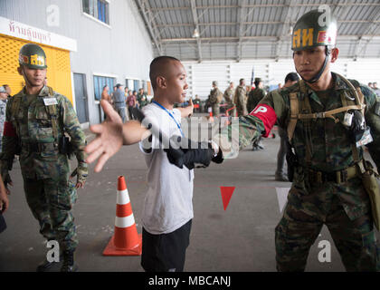 Ein Mitglied der malaysischen Armee prüft eine zivile als Teil einer Praxis noncombatant Evakuierung Betrieb, Feb 17, 2018. Diese Ausbildung hat einen Schauplatz sowohl für die Vereinigten Staaten und Partner Nationen Interoperabilität und Erhöhung der Kapazitäten in der Planung und Abwicklung von komplexen und realistischen multinationale Truppe vorzurücken und kombinierte Task Force. Übung Cobra Gold 2018 ist eine jährliche Übung im Königreich Thailand durchgeführt wurde von Feb.13-23 mit sieben voll teilnehmenden Nationen. (U.S. Marine Stockfoto