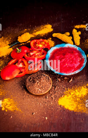 Nahaufnahme von Tomatenmark, Sandelholz, Kurkuma und seine Pulver auf einer hölzernen Oberfläche. Sie wird verwendet, um die dunklen Köpfe und schwarze Haut zu löschen. Stockfoto