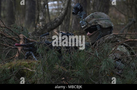 Ein US-Soldat zu Bügeleisen Truppe, 3 Staffel, 2 Cavalry Regiment zugeordnet, zieht Sicherheit während in der multinationale Übung Puma die Teilnahme an einer Reihe in der Nähe der Bemowo Piskie, Polen, 19.02.2018. Diese Soldaten sind Teil der einzigartigen, multinationalen Battle Group aus USA, Großbritannien, Kroatischen und rumänischen Soldaten, die mit der polnischen 15 mechanisierte Brigade als Abschreckung Kraft im Nordosten Polens zur Unterstützung des NATO-Enhanced vorwärts Präsenz dienen. (U.S. Armee Stockfoto