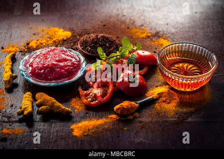 In der Nähe von Tomaten, mit Püree, Honig, Kurkuma, Pulver von Sandelholz und curcuma Puder auf Holz- Oberfläche in dunklen Gothic Farben für bessere und Hea Stockfoto