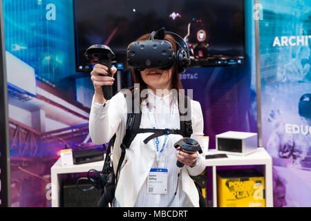 Mädchen spielen Videospiel in virtual-Reality-Kopfhörer und Handheld-Controller entwickelt von HTC Vive auf Messe Cebit 2017 in Hannover Messe, Deutschland Stockfoto