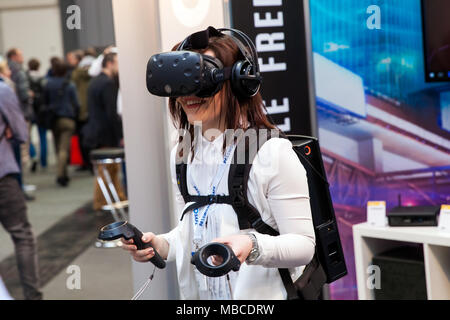 Mädchen spielen Videospiel in virtual-Reality-Kopfhörer und Handheld-Controller entwickelt von HTC Vive auf Messe Cebit 2017 in Hannover Messe, Deutschland Stockfoto