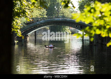 Ein Mann ein Kajak paddeln unter einer Brücke entlang des Landwehrkanals in der Kreuzberger Nachbarschaft von Berlin, Deutschland. Stockfoto