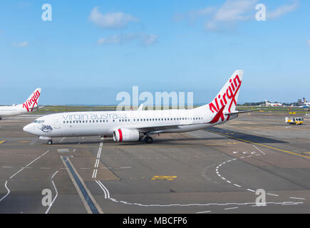 Eine Jungfrau Australien Boeing 737-800 Flugzeuge auf der Rollbahn am Flughafen Sydney, Australien Stockfoto