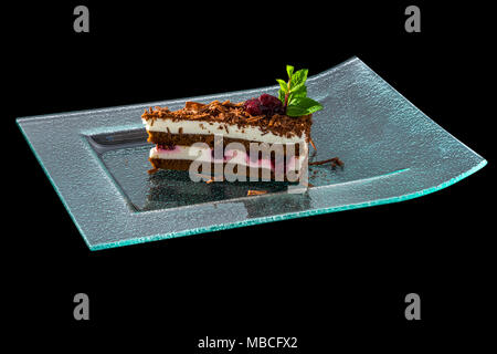 Stück Schokoladenkuchen mit Milch, Sahne und Cranberry jam Stockfoto