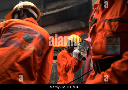 Feuerwehrleute gesehen Bekämpfung des Brandes in der Fabrik gebäude. Mindestens 34 Arbeiter in einem Feuer, das durch eine Fabrik in Bangladesch zerrissen enthalten. Das Feuer war so heftig Es dauerte Feuerwehr 36 Stunden zu löschen - und Rettungskräfte konnte immer noch nicht das Gebäude danach geben Sie aus Angst es zusammenbrechen würde. Mannschaften sind noch Clearing durch das Geröll. Stockfoto