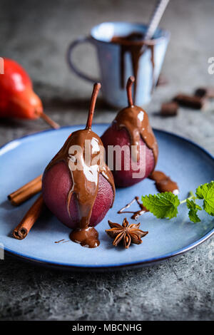Lecker gewürzt Rotwein pochierte Birnen mit Schokoladensauce Stockfoto