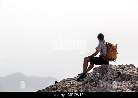 Menschen wandern Silhouette in den Bergen, Inspiration und Motivation. Wanderer mit Rucksack auf der Oberseite des Berges auf die schöne Landschaft. Stockfoto