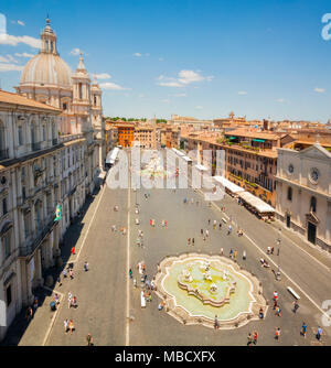 Blick auf den berühmten Piazza Navona in Rom an einem sonnigen Tag mit Touristen zu Fuß. Die barocke Architektur. Reisen und Tourismus Stockfoto