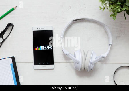 WROCLAW, Polen - 29. MÄRZ 2018: Deezer ist eine Musik Service, bietet rechtliche Streaming Musik. Smartphone mit Deezer app Logo auf dem Schreibtisch Konzept. Stockfoto