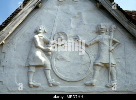 Riesige Gog und Magog. Die riesigen Helden, Gog und Magog, in pargetting auf der Fassade der alten Sun Inn, Saffron Walden. Der Fall der Sonnenlicht auf diese Zahlen zeigen verschiedene versteckte Symbole Stockfoto