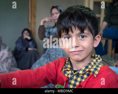 Kang, Iran - 30. Juli 2016: portrait eines iranischen Kind mit seiner Familie im Hintergrund Stockfoto