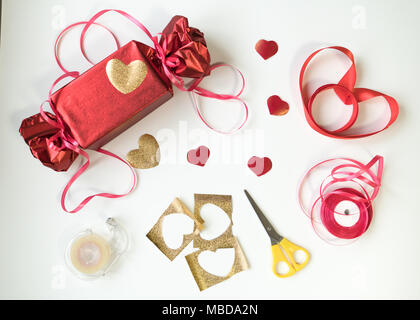 Valentinstag. Red Box mit einem Bogen und Bänder. Herzen, Blumen und Geschenke. Stockfoto