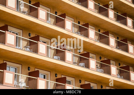 Eine Nahaufnahme der Balkone, die zu einem Hotel in Santa Susanna, Spanien einheitlich angelegt mit Picknick Tischen und Stühlen. Stockfoto