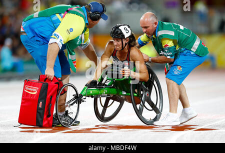 Kanadas Jessica Frotten ist nach einem Absturz während der Frauen T54 1500 m-Finale bei den Carrara Stadion am Tag sechs der 2018 Commonwealth Games in der Gold Coast, Australien geholfen. Stockfoto