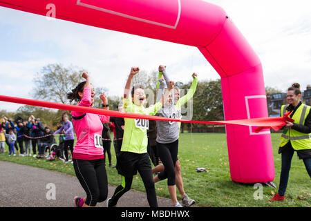 Begeisterte Familie Läufer liebe Kreuzung laufen Finish Line in Park Stockfoto