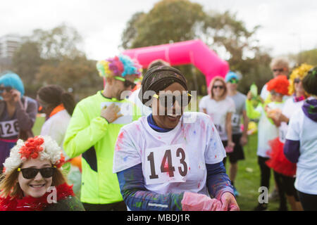 Lachend Läuferin im Holi Pulver in den spendenlauf in Park abgedeckt Stockfoto