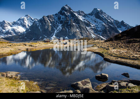 Schnee auf Remote, sonnig, zerklüfteten Bergen über Wasser, Maervoll, Lofoten, Norwegen Stockfoto