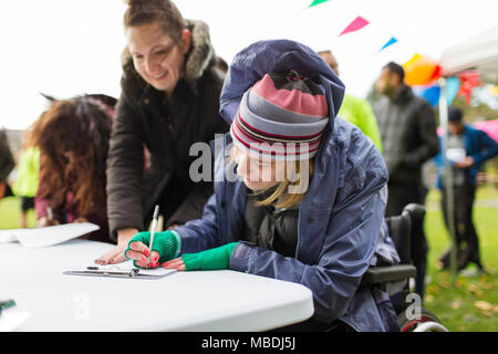 Frau im Rollstuhl an Charity Rennen Stockfoto