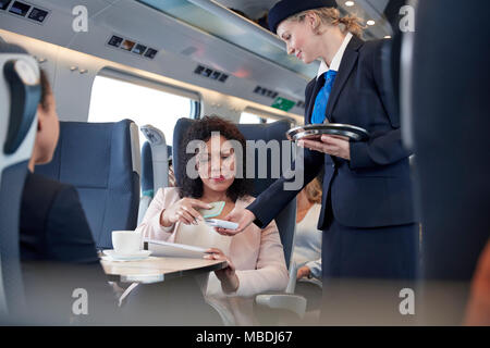 Geschäftsfrau mit Smart über kontaktlose Zahlung Telefon, Anrufannahme im Personenzug Stockfoto