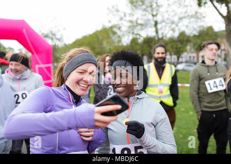 Läuferin Freunden über Smart Phone an der Nächstenliebe laufen im Park Stockfoto