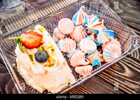 Scheibe der Swiss roll und bunten meringue Küsse Stockfoto