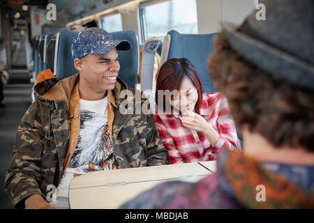 Junges Paar Lachen auf Personenzug Stockfoto