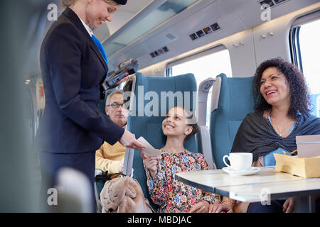 Attendant prüfen Ticket von Mutter und Tochter auf Personenzug Stockfoto